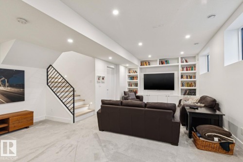 Spacious living area featuring light-colored carpeting, recessed lighting, and a window - 11146 62 Street Nw, Edmonton, AB - Indoor