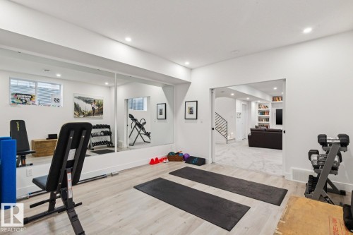 Dedicated fitness area featuring light-toned flooring, recessed lighting, and a mirrored wall - 11146 62 Street Nw, Edmonton, AB - Indoor