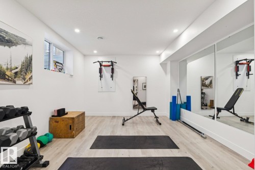 Dedicated fitness room featuring light wood-style flooring, recessed lighting, and a mirrored wall - 11146 62 Street Nw, Edmonton, AB - Indoor Photo Showing Gym Room
