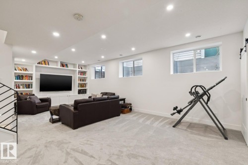 Spacious living area featuring light-colored carpeting, recessed lighting, and windows providing natural light - 11146 62 Street Nw, Edmonton, AB - Indoor