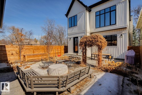 The property features a private backyard with a paved patio area, a wooden fence, and a built-in bench seating area - 11146 62 Street Nw, Edmonton, AB - Outdoor