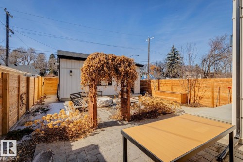The property features a fenced yard with a paved patio area, a wooden pergola, and a detached structure - 11146 62 Street Nw, Edmonton, AB - Outdoor