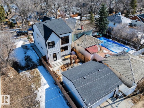 This property features a modern exterior design with white siding and black accents, a dark-shingled roof, and a fenced yard - 11146 62 Street Nw, Edmonton, AB - Outdoor