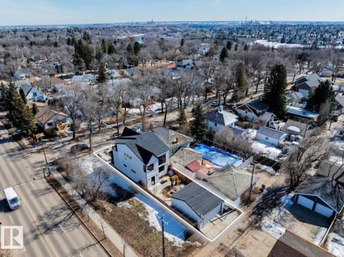 Aerial view of the property, featuring a modern style main residence with a dark roof, an additional detached building, and a swimming pool - 11146 62 Street Nw, Edmonton, AB - Outdoor With View