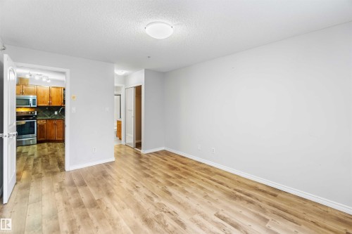 This open space features light-toned walls and wood-look flooring, creating a bright and inviting atmosphere - 319 17415 99 Avenue, Edmonton, AB - Indoor Photo Showing Other Room