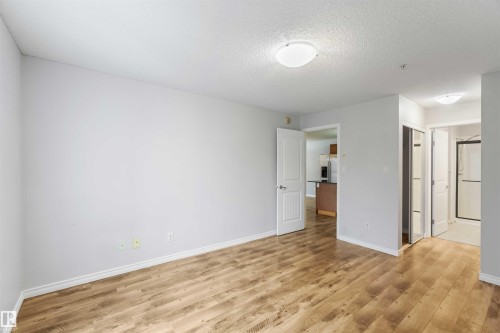 This room features light-colored walls and wood-look flooring - 319 17415 99 Avenue, Edmonton, AB - Indoor Photo Showing Other Room
