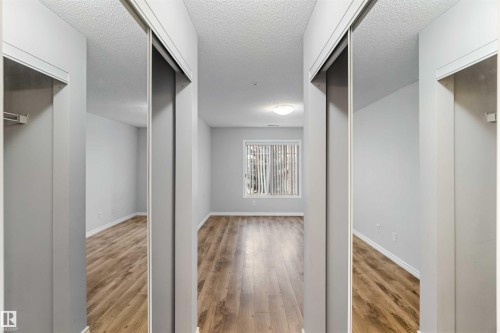 This room features durable laminate flooring, light gray walls, and a window with vertical blinds, providing a bright and airy atmosphere - 319 17415 99 Avenue, Edmonton, AB - Indoor Photo Showing Other Room