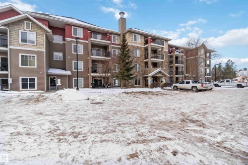 The property is a multi-story building featuring a facade of mixed materials including siding and stone accents - 319 17415 99 Avenue, Edmonton, AB - Outdoor With Facade