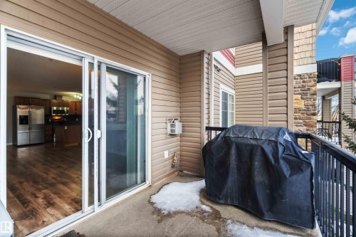 A private balcony with a concrete floor and black metal railings, offering an outdoor extension to the living space - 319 17415 99 Avenue, Edmonton, AB - Outdoor With Deck Patio Veranda With Exterior