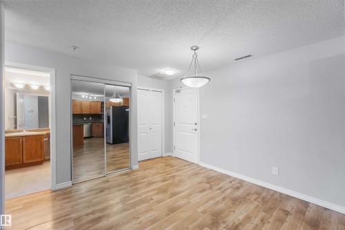 Entrance space featuring light wood-style flooring and ight grey walls. - 319 17415 99 Avenue, Edmonton, AB - Indoor Photo Showing Other Room