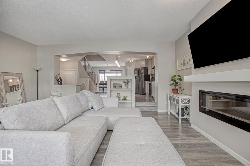 The living area features light-colored flooring and a built-in fireplace with a mantel - 7718 Eifert Crescent, Edmonton, AB - Indoor Photo Showing Living Room With Fireplace