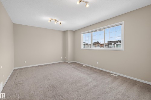 Spacious room featuring carpeting, light-colored walls, and windows providing natural light - 4723 Alwood Bend, Edmonton, AB - Indoor Photo Showing Other Room