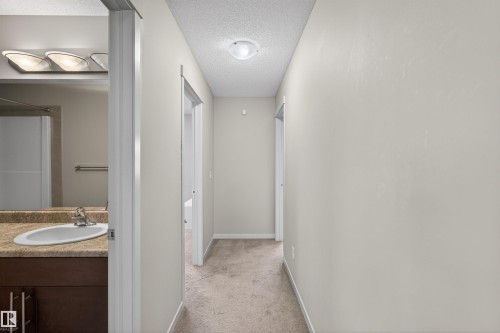Hallway with neutral-toned walls and carpet flooring, featuring a ceiling light fixture - 4723 Alwood Bend, Edmonton, AB - Indoor Photo Showing Bathroom