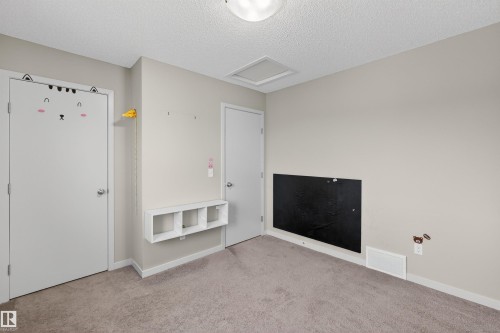 This room features neutral-toned walls, a textured ceiling with a flush-mount light fixture, and carpeted flooring - 4723 Alwood Bend, Edmonton, AB - Indoor Photo Showing Other Room