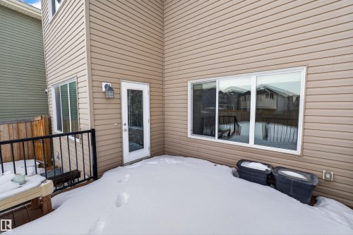 This property features a private deck area with black metal railings, accessible via a glass-paneled door - 4723 Alwood Bend, Edmonton, AB - Outdoor With Deck Patio Veranda With Exterior