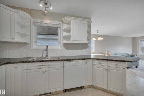 Kitchen featuring white cabinetry, a double basin sink, and a dishwasher, with granite-style countertops - 5 Parkview Crescent, Calmar, AB - Indoor Photo Showing Kitchen With Double Sink