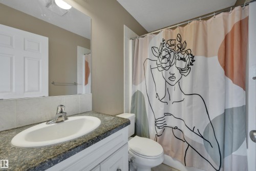 The bathroom features a vanity with a white sink, a dark countertop, and a mirror - 5 Parkview Crescent, Calmar, AB - Indoor Photo Showing Bathroom