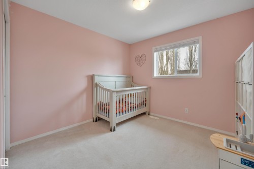 This room features a window providing natural light, light-colored carpeting, and a ceiling-mounted light fixture - 5 Parkview Crescent, Calmar, AB - Indoor Photo Showing Bedroom