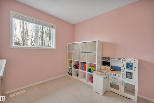 This room features a window providing natural light, light-colored carpeting, and light pink walls - 5 Parkview Crescent, Calmar, AB - Indoor