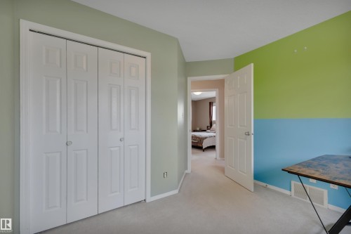 This room features light-colored carpeting and walls painted in a two-tone scheme of lime green and blue - 5 Parkview Crescent, Calmar, AB - Indoor
