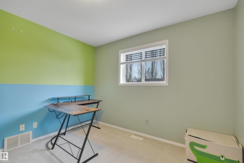 This room features light-colored carpeting, a window with blinds, and walls painted in a combination of light green and blue - 5 Parkview Crescent, Calmar, AB - Indoor