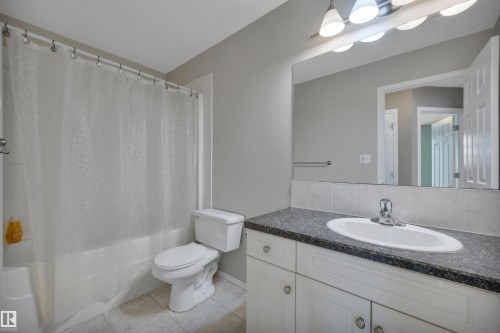 Bathroom featuring a white vanity with a dark countertop, a built-in sink, and a large mirror - 5 Parkview Crescent, Calmar, AB - Indoor Photo Showing Bathroom
