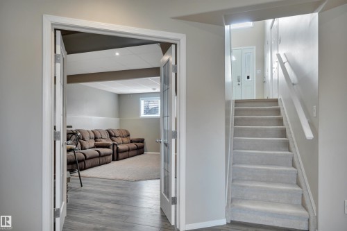 The property features a staircase with carpeted treads and a handrail - 5 Parkview Crescent, Calmar, AB - Indoor Photo Showing Other Room