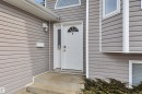 The property features gray horizontal siding with white trim, a white front door with an arched glass insert, and a white mailbox - 5 Parkview Crescent, Calmar, AB  - Outdoor With Exterior 