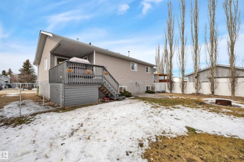 The property features a spacious backyard with a deck, a fire pit, and a chain-link fence - 5 Parkview Crescent, Calmar, AB - Outdoor