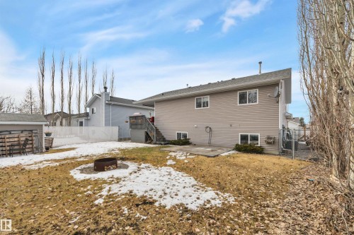The property features a spacious backyard with a fire pit, a shed, and a wooden deck - 5 Parkview Crescent, Calmar, AB - Outdoor