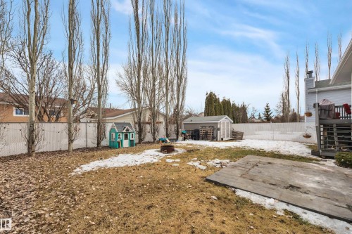 The property features a fenced backyard with a shed, a deck, and mature trees - 5 Parkview Crescent, Calmar, AB - Outdoor