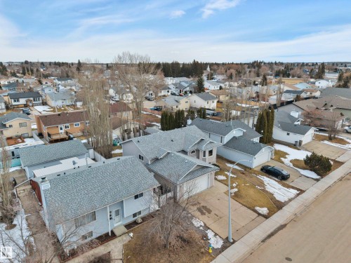 This aerial view showcases the property's grey shingle roof and a paved driveway - 5 Parkview Crescent, Calmar, AB - Outdoor With View