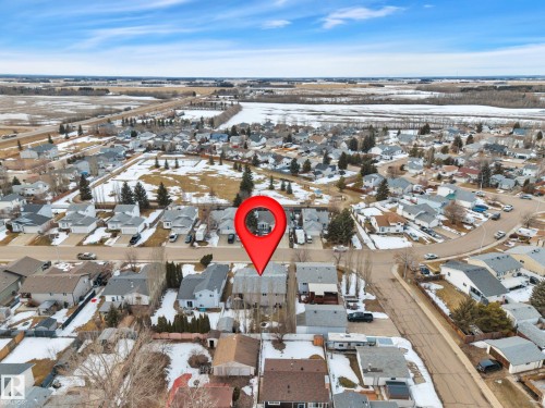 Aerial view showcasing the residential neighbourhood, surrounded by open fields and distant trees - 5 Parkview Crescent, Calmar, AB - Outdoor With View