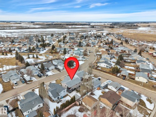 This aerial view showcases a residential area with a collection of properties, each featuring a pitched roof - 5 Parkview Crescent, Calmar, AB - Outdoor With View