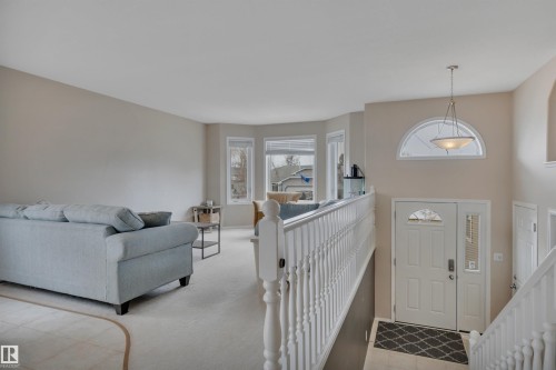 The property features an entryway with a white door, a half-moon window above, and a hanging light fixture - 5 Parkview Crescent, Calmar, AB - Indoor