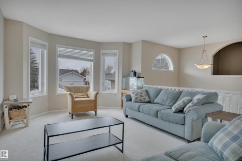 Living area featuring a bay window, an arched window, and a ceiling light fixture - 5 Parkview Crescent, Calmar, AB - Indoor Photo Showing Living Room