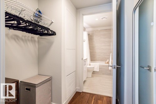 The property features a closet with a wire shelf and a bathroom with a bathtub, toilet, and tiled walls and floor - 2506 10360 102 Street, Edmonton, AB - Indoor Photo Showing Bathroom