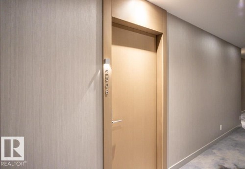Entryway featuring a solid door with modern numbering, recessed lighting, and textured wall coverings - 2506 10360 102 Street, Edmonton, AB - Indoor Photo Showing Other Room