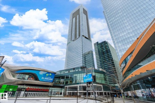 The property is situated in a vibrant urban setting, surrounded by modern high-rise buildings and features a distinctive exterior design with expansive glass facades - 2506 10360 102 Street, Edmonton, AB - Outdoor