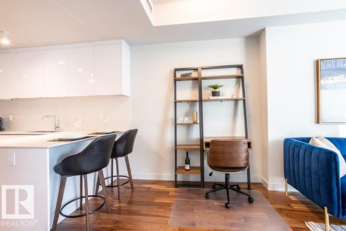 Modern kitchen featuring white cabinetry and a breakfast bar with seating for two - 2506 10360 102 Street, Edmonton, AB - Indoor