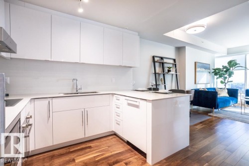 The kitchen features white cabinetry, a stainless steel sink, and light-colored countertops - 2506 10360 102 Street, Edmonton, AB - Indoor Photo Showing Kitchen With Double Sink