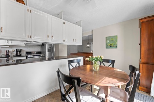 The kitchen features white cabinetry, a white subway tile backsplash, and dark countertops - 4003 50A Avenue, Cold Lake, AB - Indoor Photo Showing Dining Room