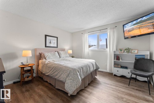 The property features a room with wood-look flooring, light-colored walls, and a window with white trim - 4003 50A Avenue, Cold Lake, AB - Indoor Photo Showing Bedroom