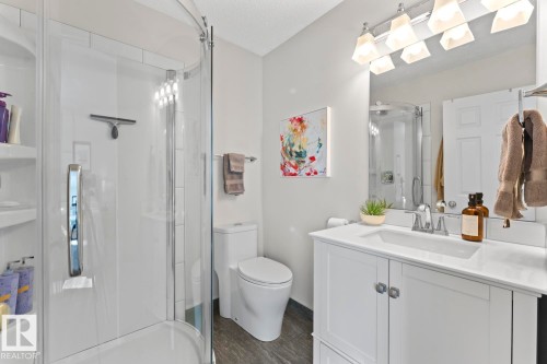 Bathroom featuring a glass-enclosed shower, a vanity with a white countertop, and a mirror with overhead lighting - 4003 50A Avenue, Cold Lake, AB - Indoor Photo Showing Bathroom