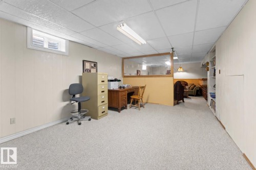 This area features light-colored carpeting, a window, and paneled walls - 4003 50A Avenue, Cold Lake, AB - Indoor Photo Showing Other Room