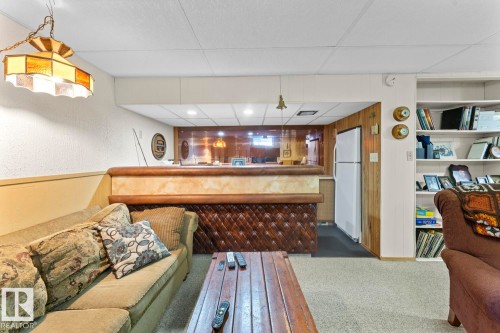 Recreation area featuring a built-in bar with wood paneling, a refrigerator, and recessed lighting - 4003 50A Avenue, Cold Lake, AB - Indoor Photo Showing Other Room