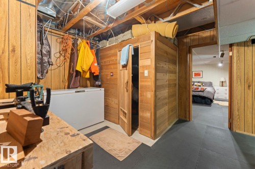 This versatile area features wood paneling, exposed ceiling beams, and durable flooring, offering functional space - 4003 50A Avenue, Cold Lake, AB - Indoor Photo Showing Basement