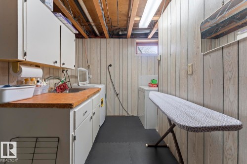 The property features a dedicated laundry area with overhead cabinetry, a countertop, and a utility sink - 4003 50A Avenue, Cold Lake, AB - Indoor