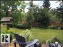 Expansive yard featuring a well-maintained lawn and mature trees, offering a tranquil outdoor setting - 4003 50A Avenue, Cold Lake, AB  - Outdoor 
