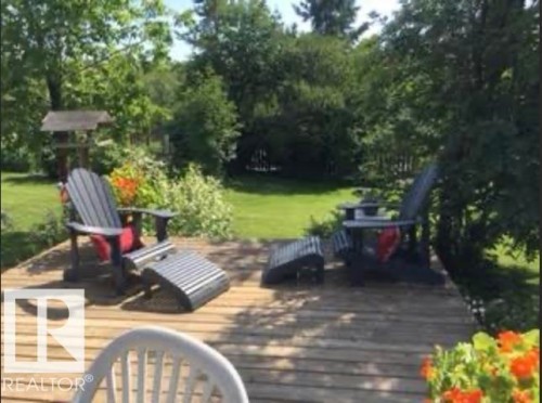 Expansive outdoor deck with mature trees, a lush lawn, and vibrant plantings - 4003 50A Avenue, Cold Lake, AB - Outdoor With Deck Patio Veranda